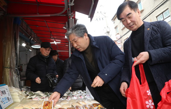 수원시 정자시장에서 떡을 구매하고 있는 송한준 경기도의회 의장.