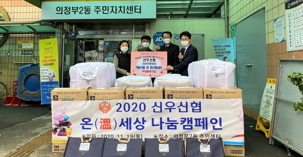 김명철 이사장(오른쪽에서 두번째), 신용호 부장(右) 등이 의정부2동주민센터를 방문해 300만원 상당의 후원물품을 기탁한 후 기념 촬영을 하고 있다.