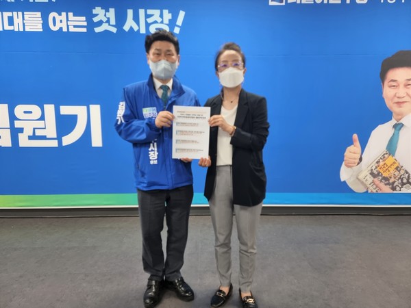 김원기 후보(왼쪽)가 박세나 의정부지역아동센터연합회장(왼쪽)으로부터 정책제안서를 받은 후 포즈를 취하고 있다.