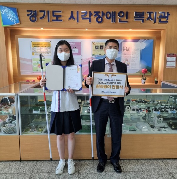청심국제고 김한비 학생(왼쪽)이 최근 시각장애인을 위한 흰지팡이 100개를 정옥동관장(오른쪽)에 전달한 후 기념 촬영을 하고 있다.