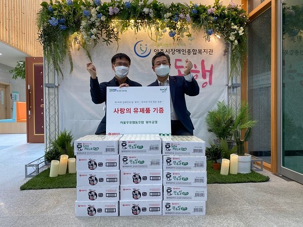 배형진 서울우유양주부공장장이 김정희 관장(우)에게 유제품 30박스를 기부했다.